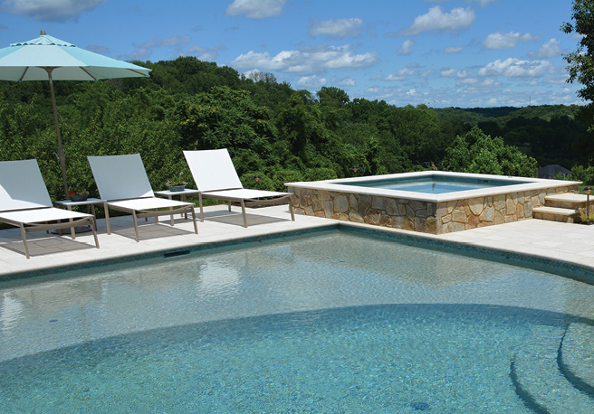 Residential pool with stone veneer accents on the spa